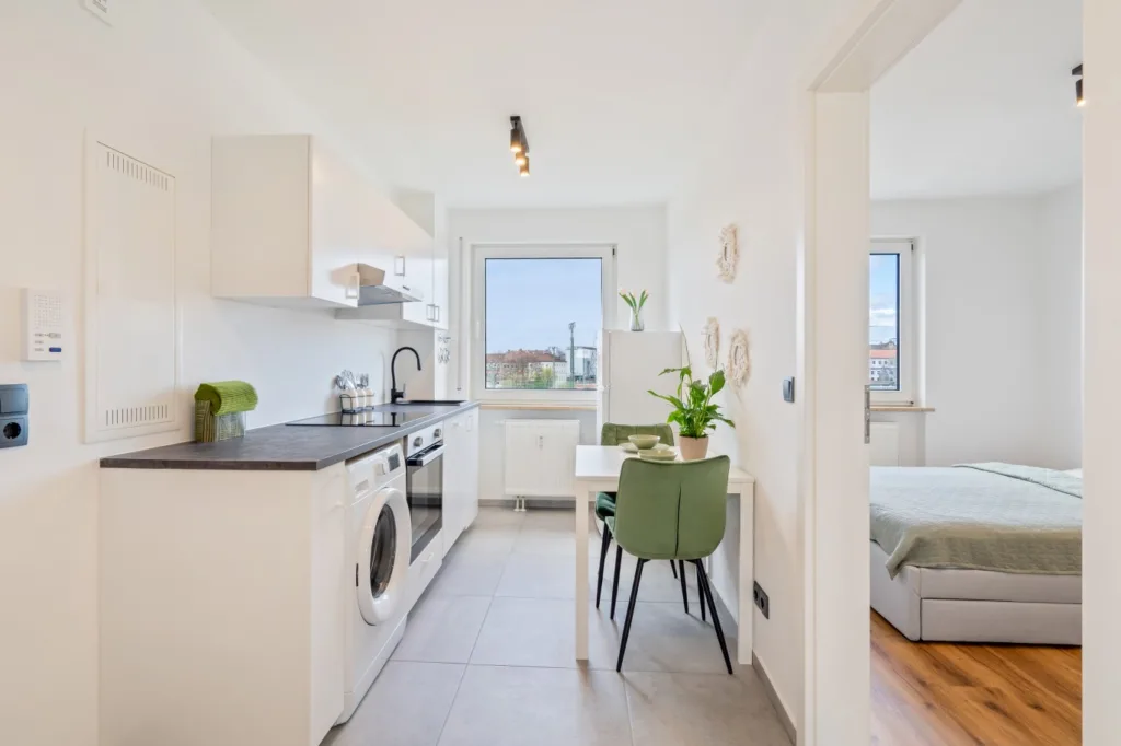 Moderne, helle Küche in Nürnberg mit Waschmaschine, Esstisch und Blick aus dem Fenster auf die Stadt